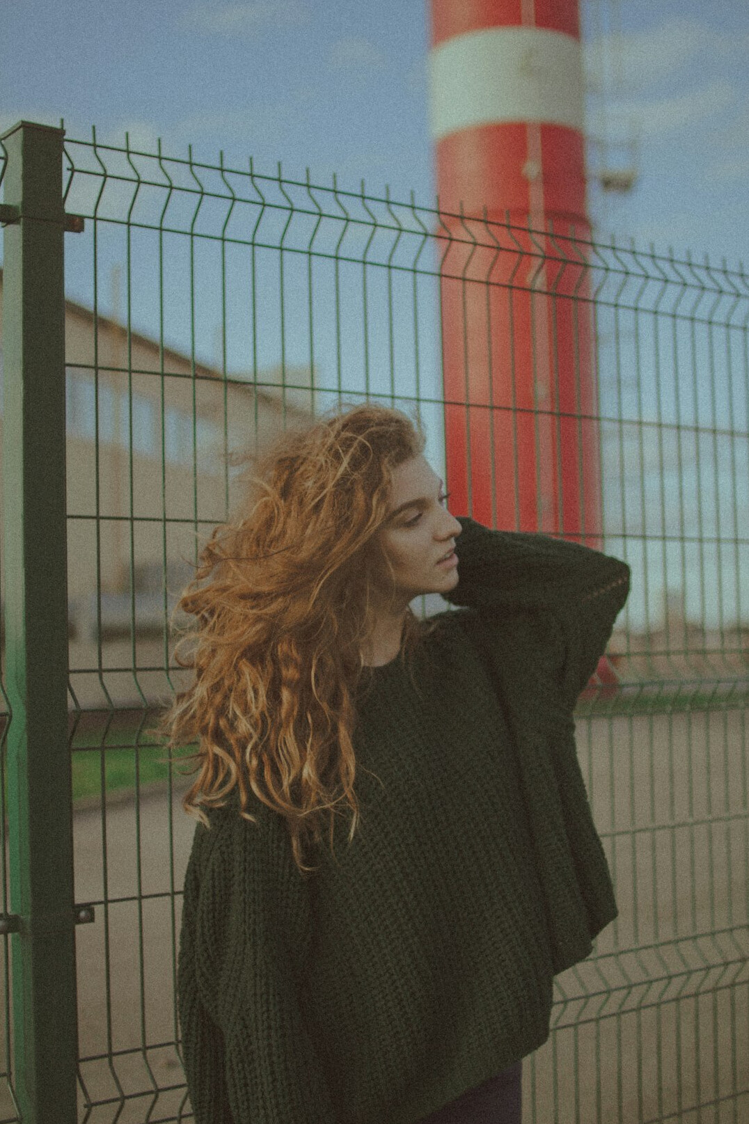 Portrait of a red-haired Croatian woman in her late twenties in a green sweater